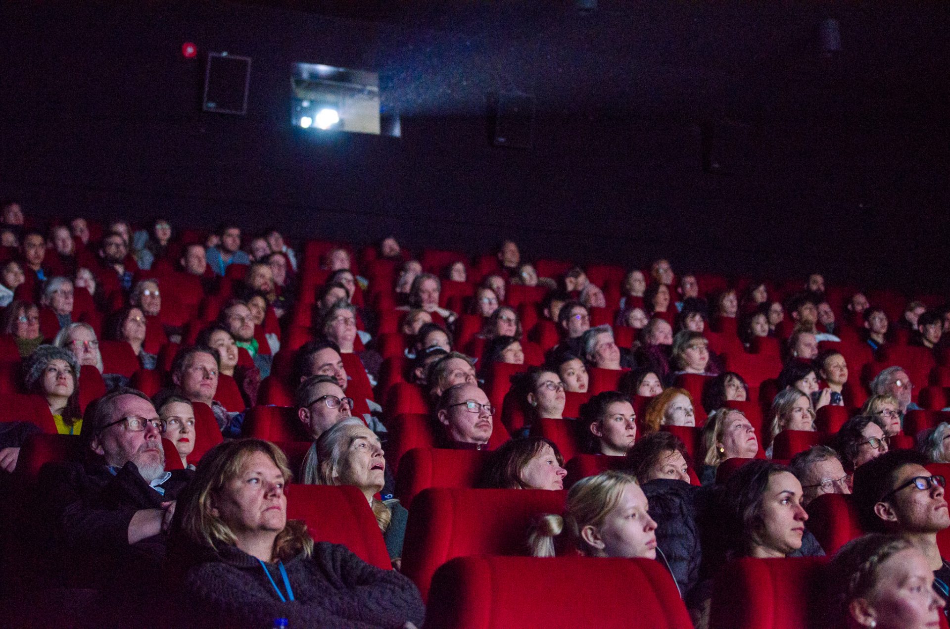 Tampereen elokuvajuhlien yleisöä elokuvateatterin punaisilla penkeillä katsomassa elokuvanäytöstä.