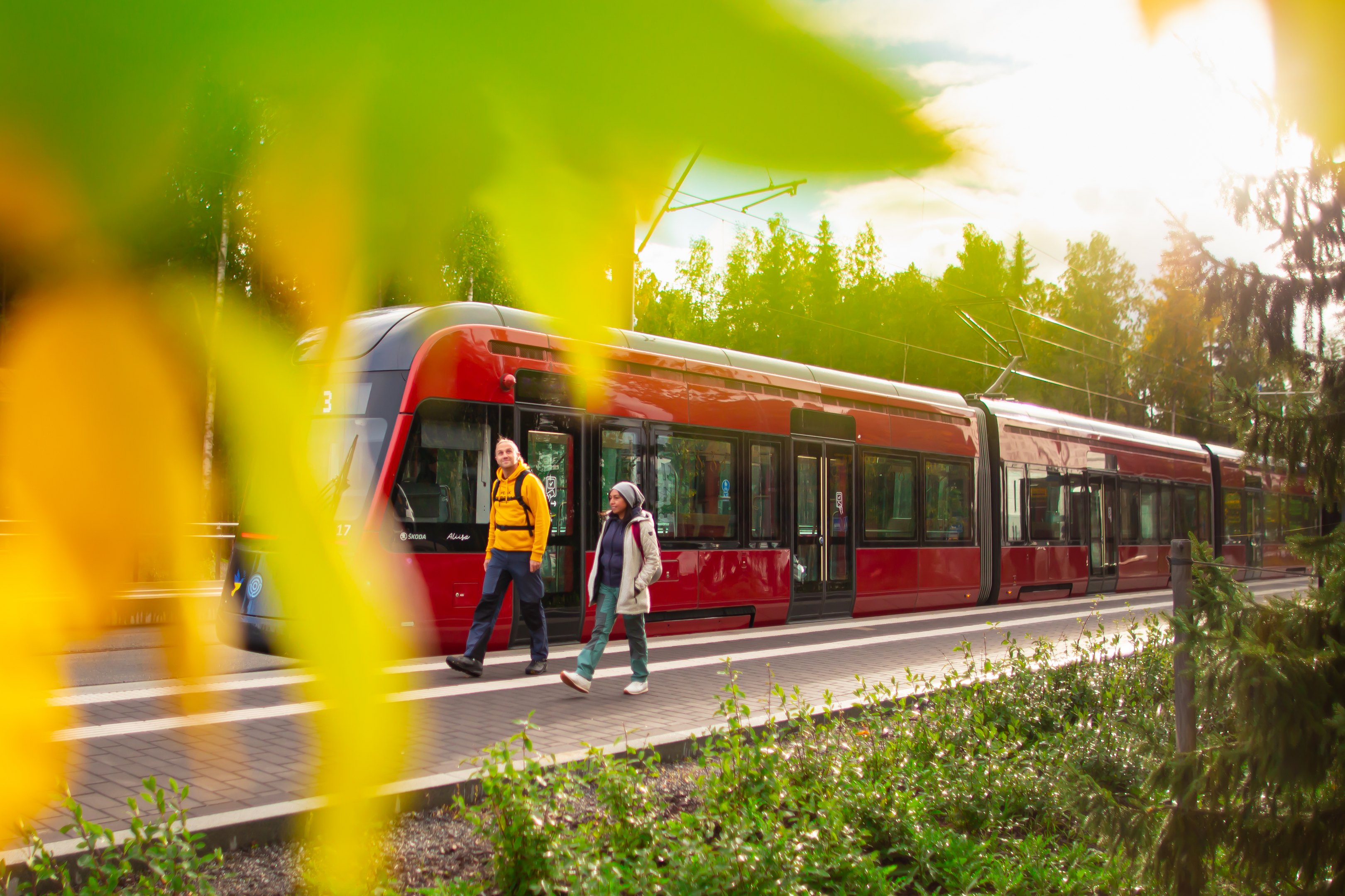 Tampereen punainen ratikka ja kaksi kävelijää laiturilla